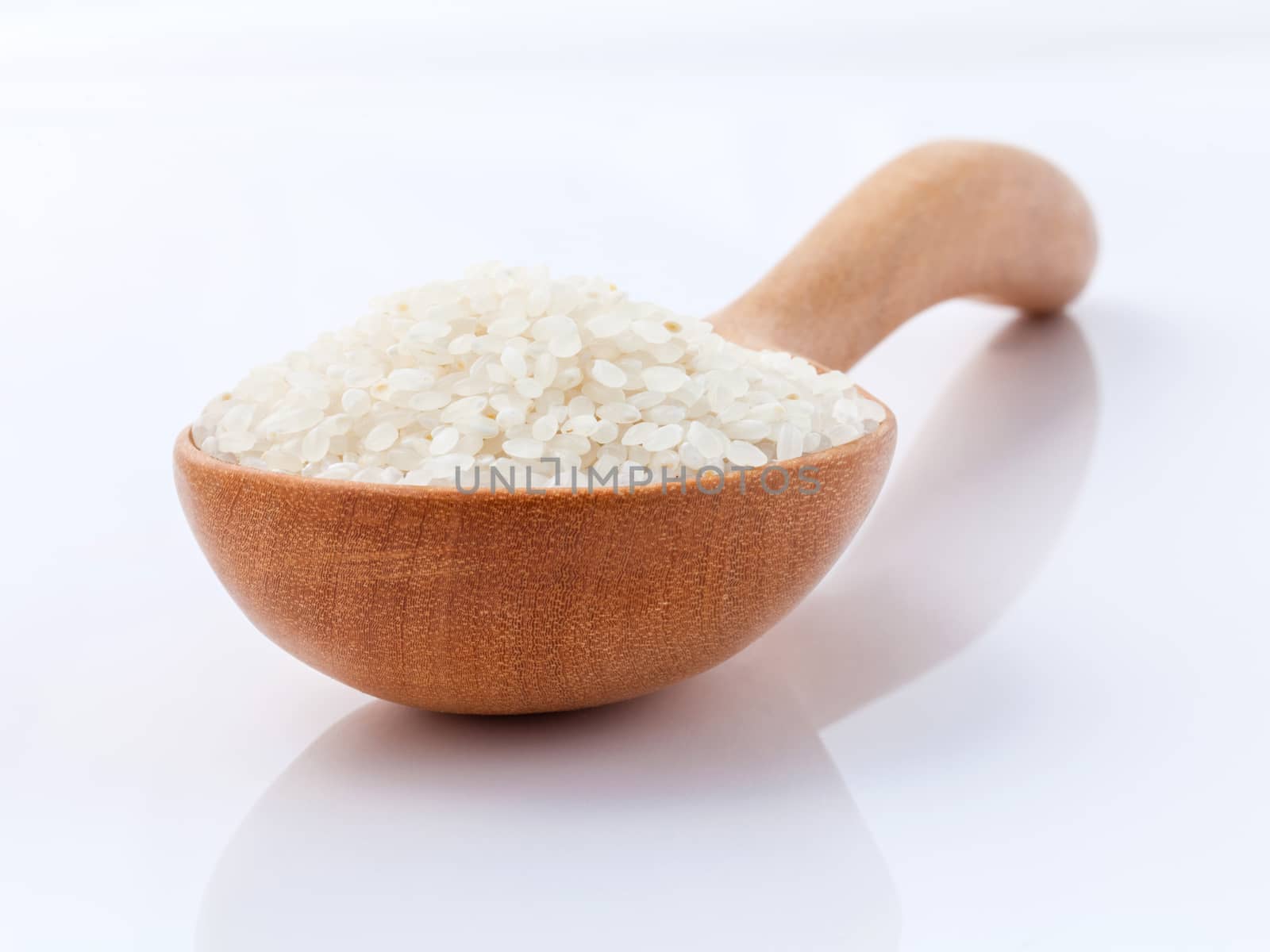 Japanese rice, the short rice used for sushi in wooden spoon with selective focus.