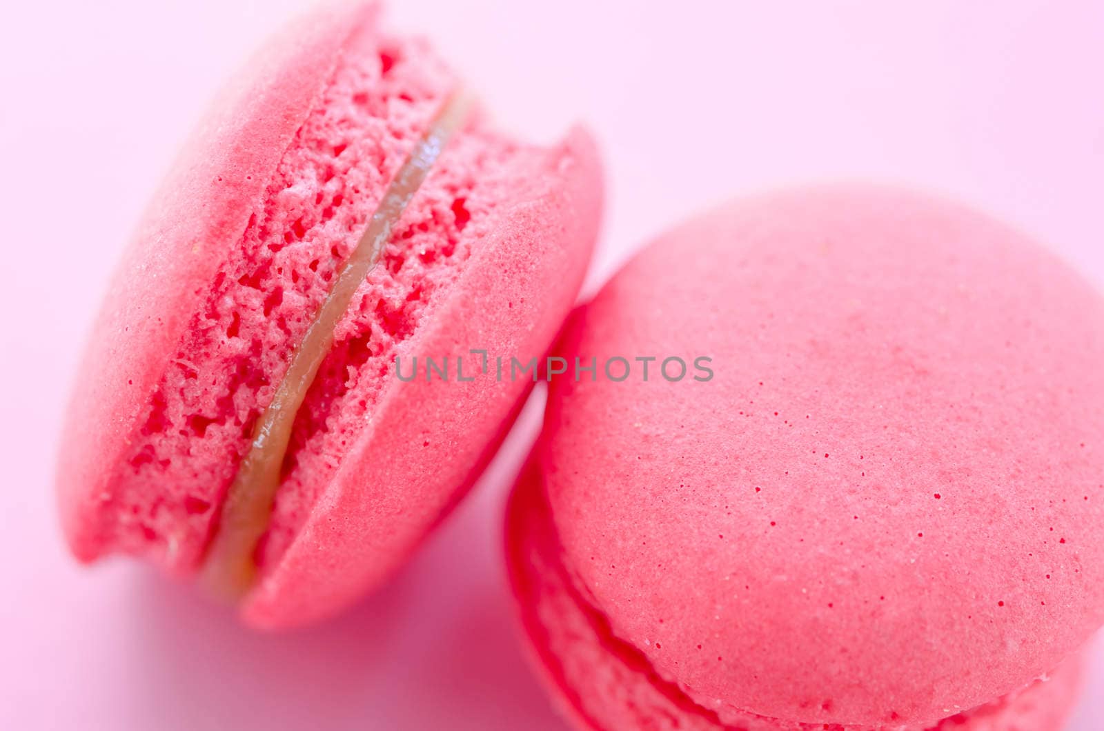 Top view of tasty pink macaroons on pink background.