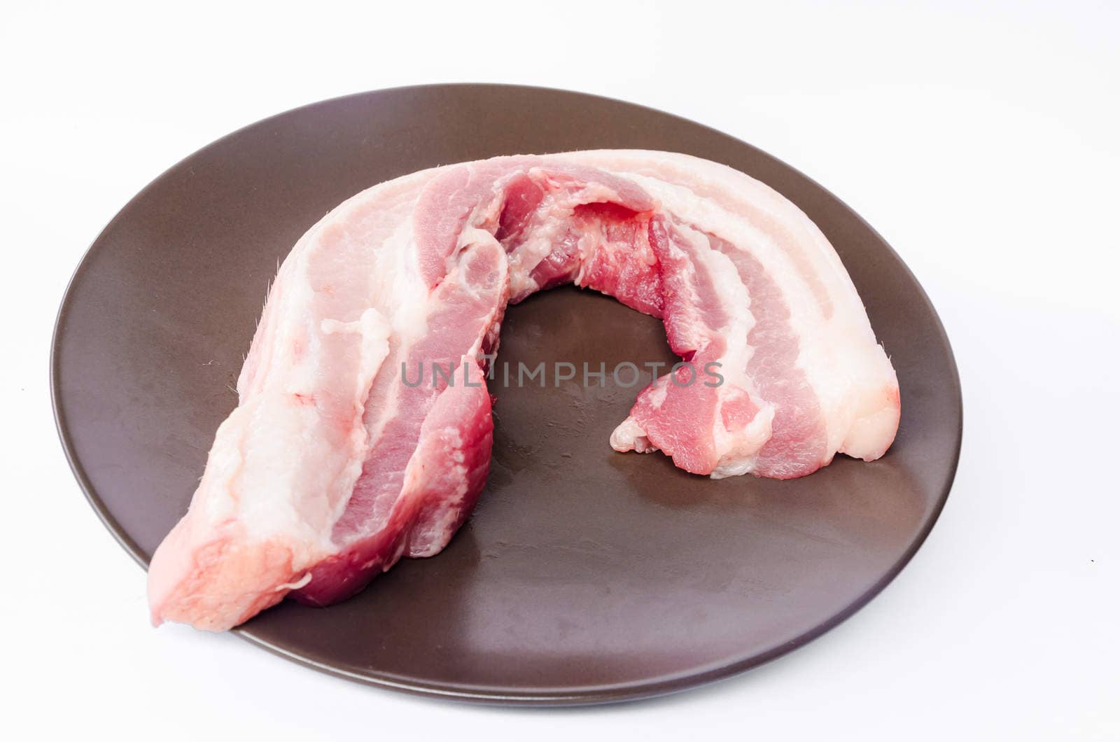 Pork bacon in the dish on white background