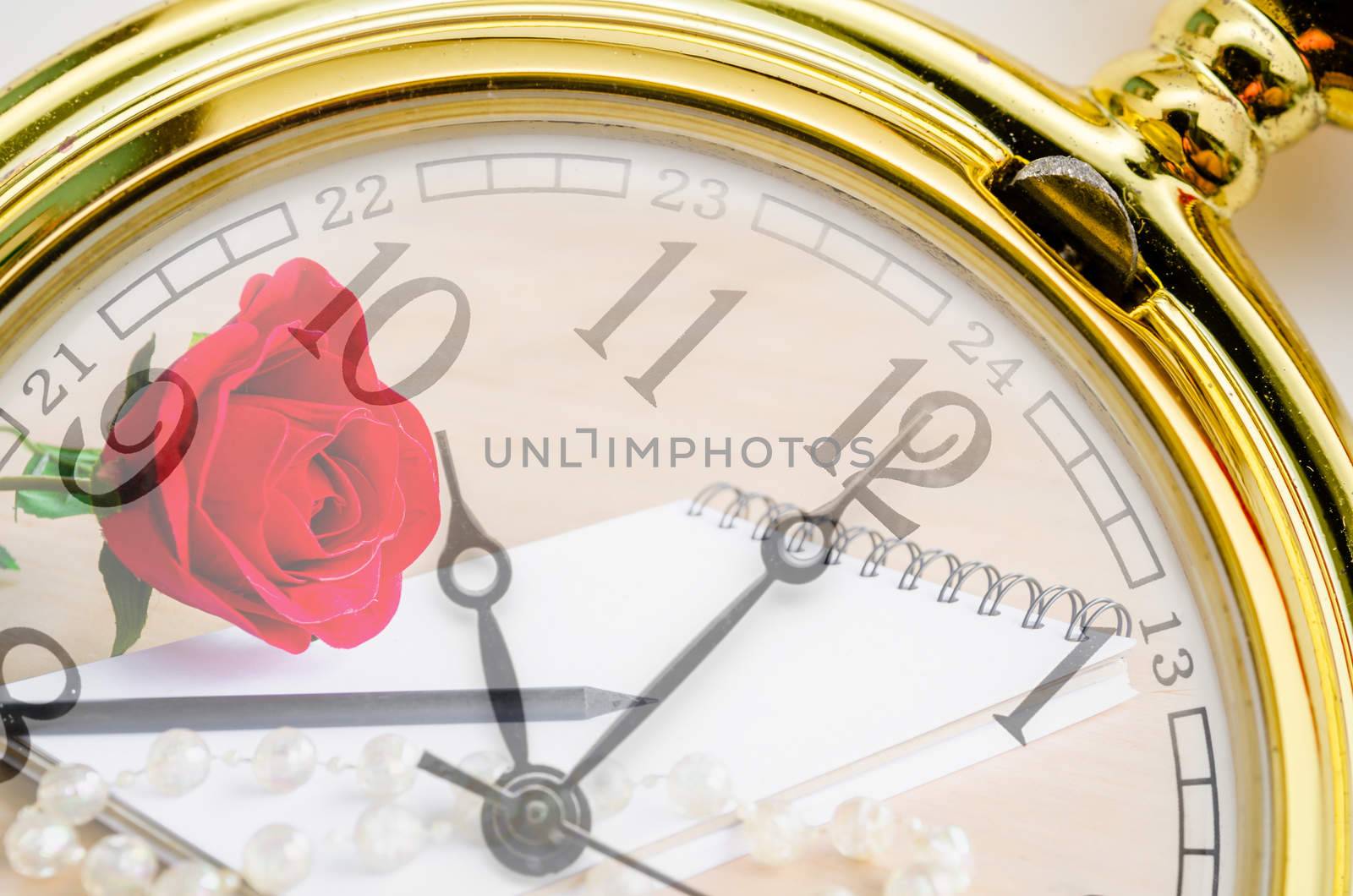 Vintage pocket watch with red rose and blank diary background. Time of love concept.