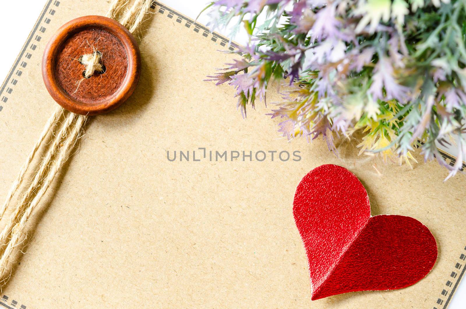 red heart paper and blank brown tag with leaf on whtie background.
