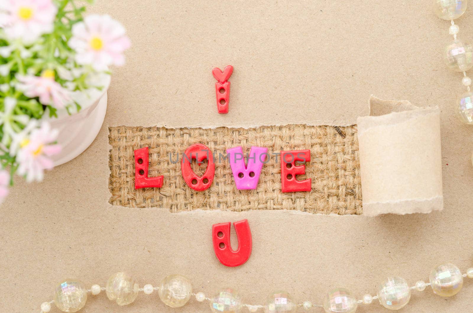 I love you alphabet on brown paper and pink flower on sack background. Love concept.