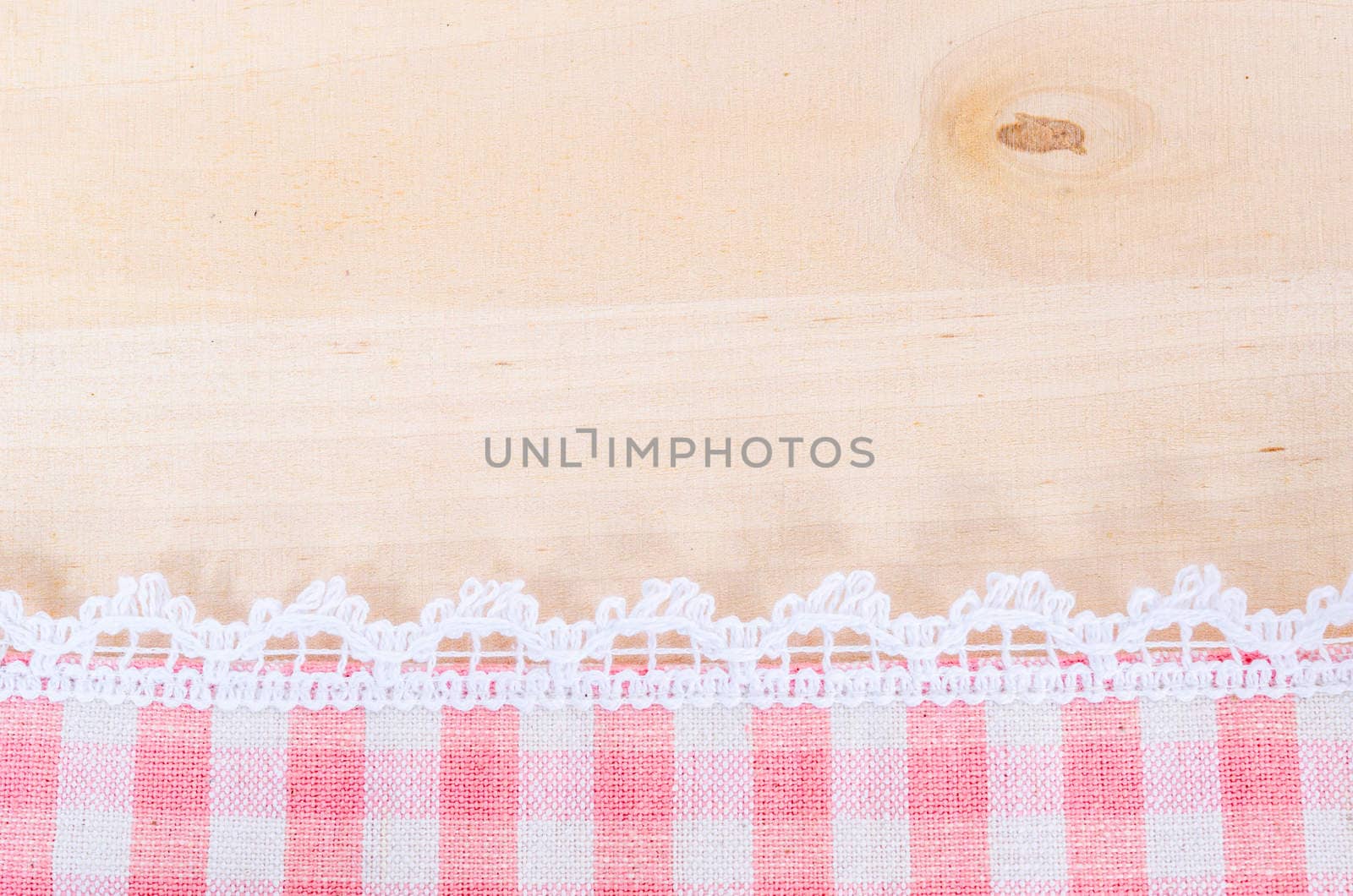 Table cloth and white lace on wooden texture or background.