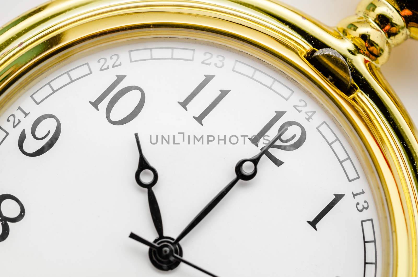 Close up gold pocket watch at ten oclock.