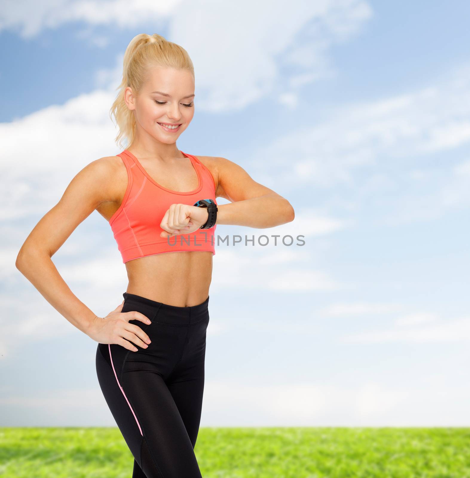 fitness, technology and exercising concept - smiling woman looking at heart rate monitor on hand