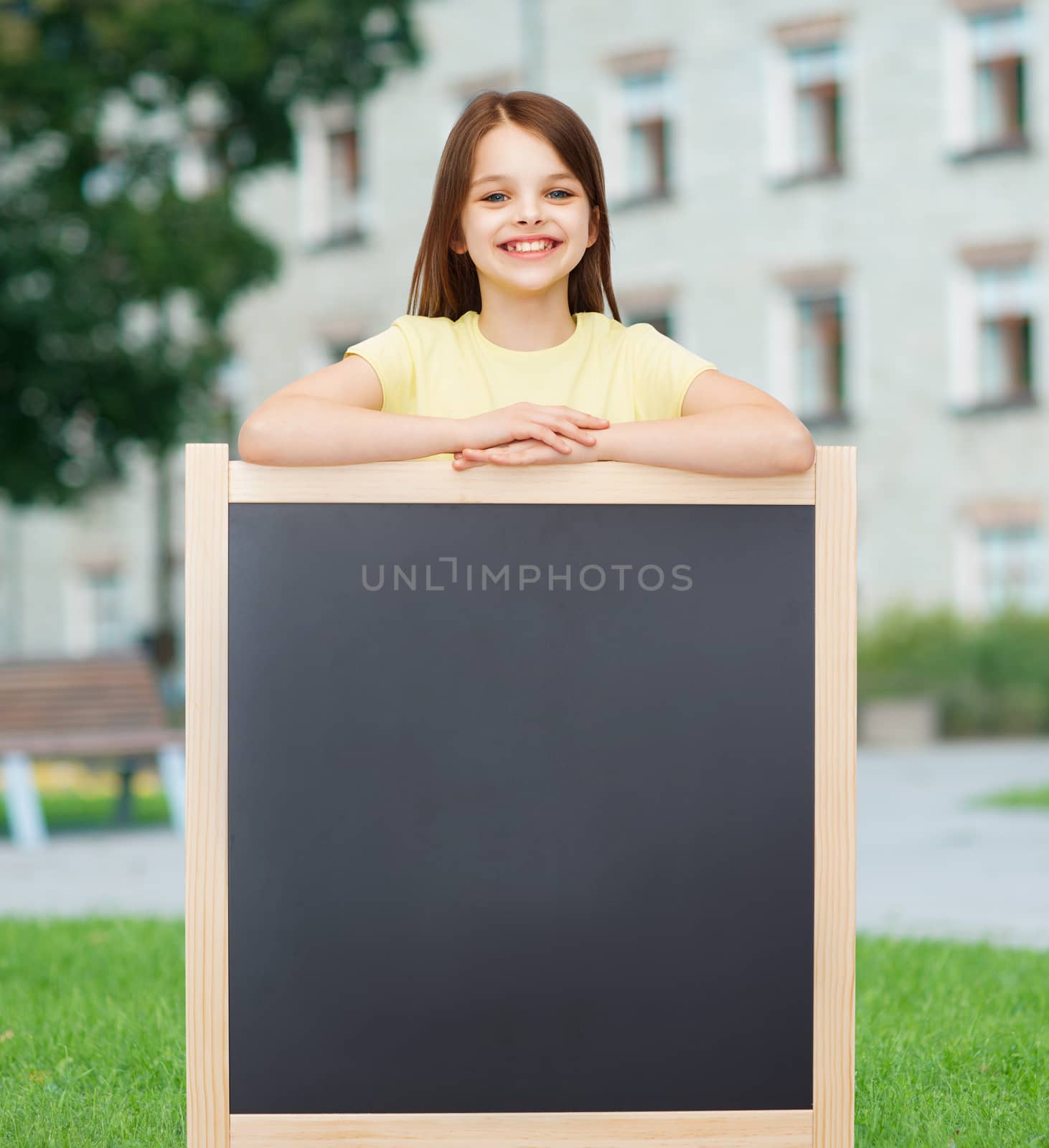 happy little girl with blank blackboard by dolgachov