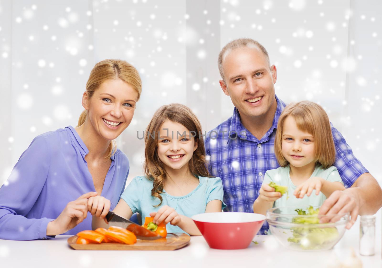 happy family with two kids making dinner at home by dolgachov