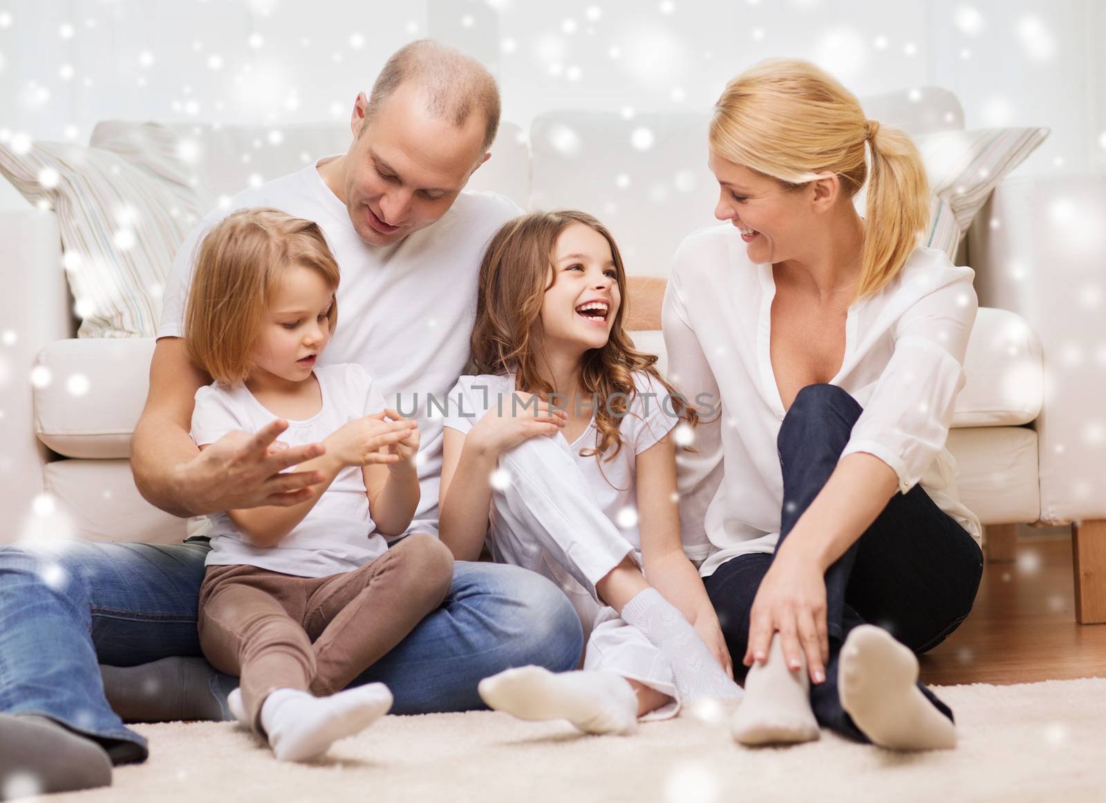 family, childhood, people and home concept - smiling parents with two little girls sitting on floor at home