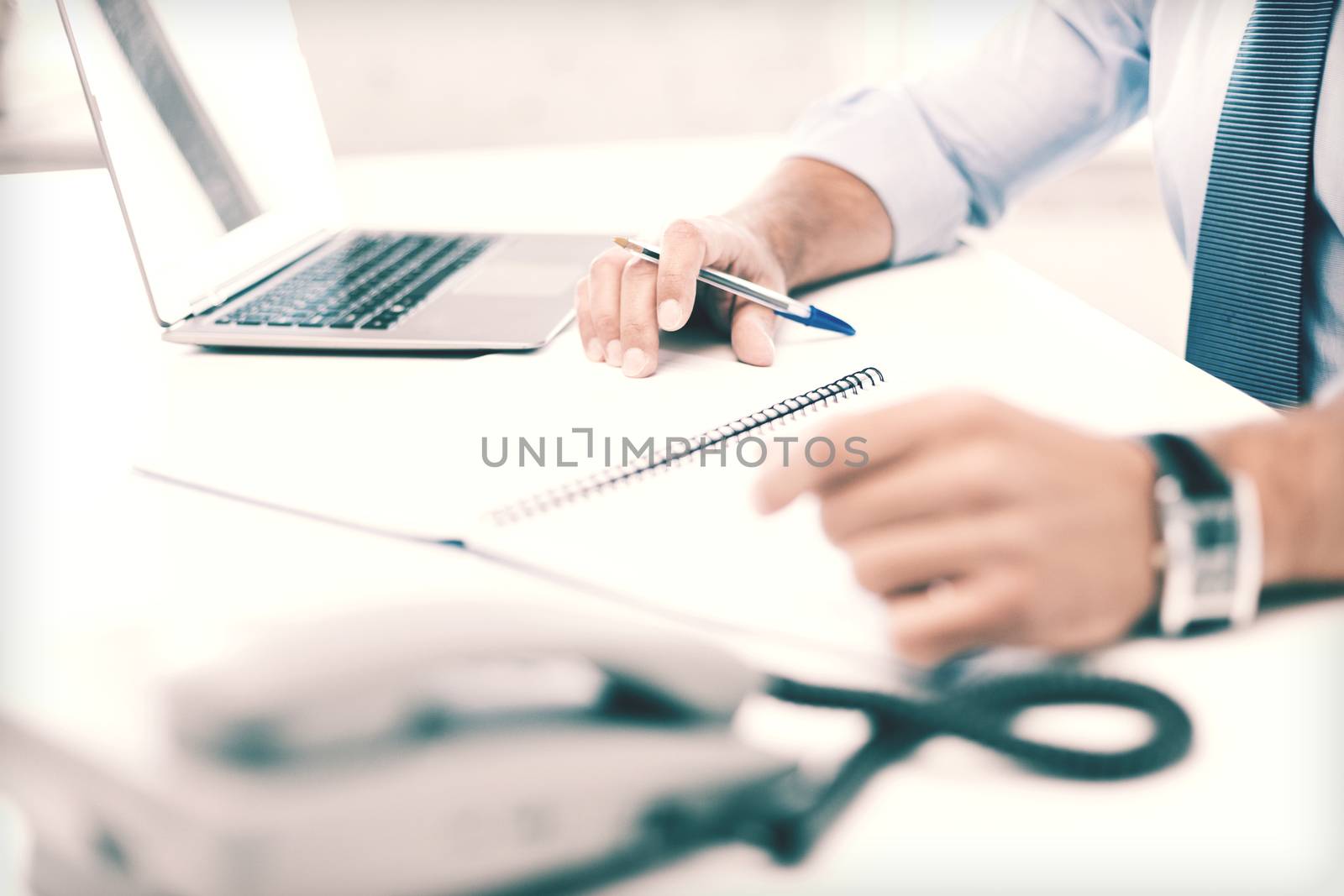 businessman writing in notebook by dolgachov