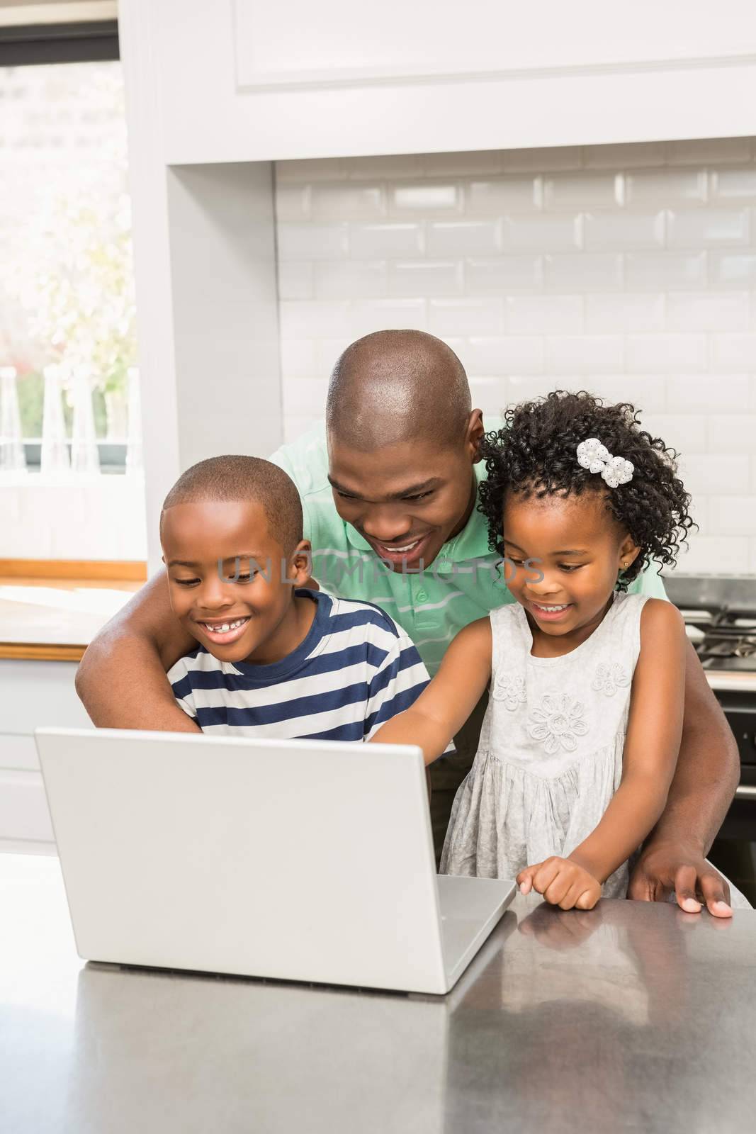 Father using laptop with his children in kitchen in kitchen at home