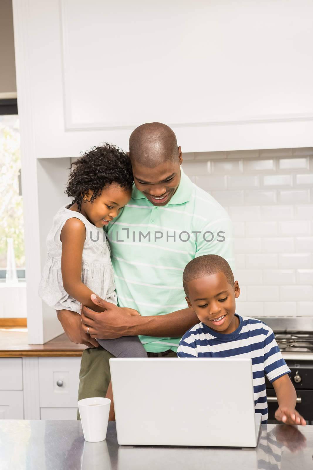 Happy family using laptop in the kitchen 