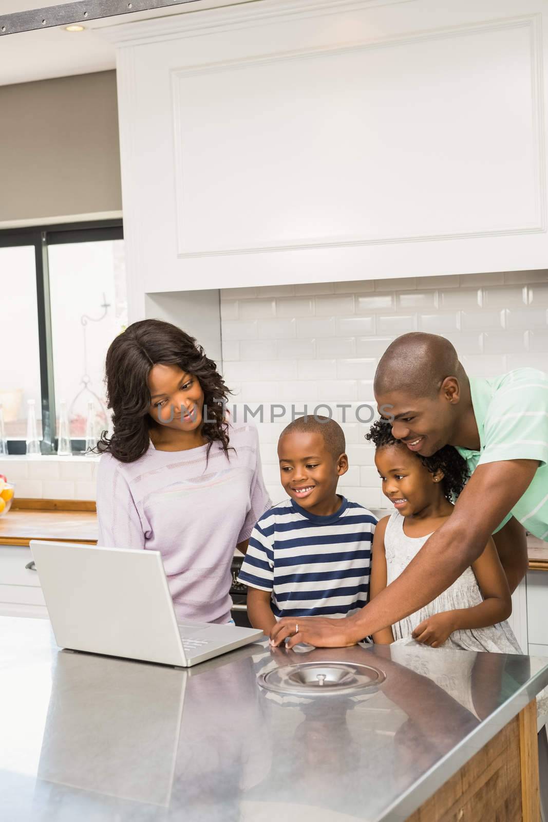 Happy family using laptop in the kitchen 