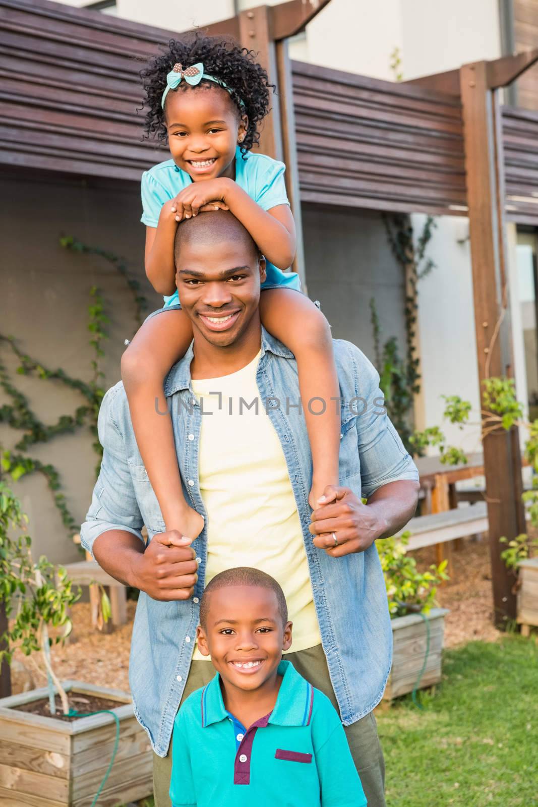 Happy father and children in the garden of the new house