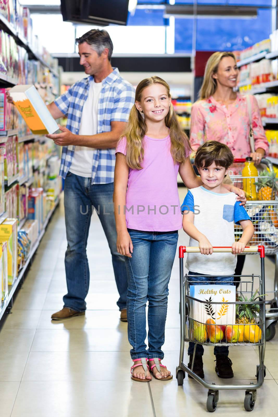 Happy family at the supermarket with kids in foreground