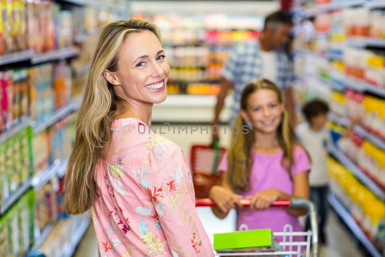 Smiling woman with her family at the supermarket