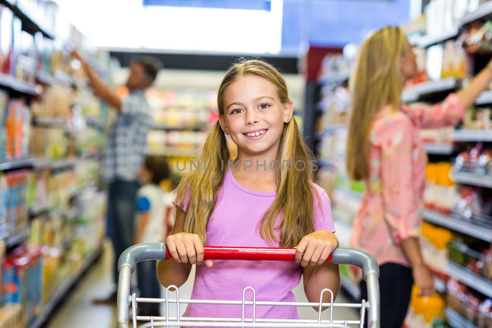 Smiling child with her family in the supermarket