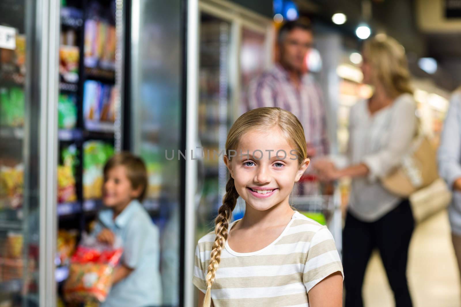 Smiling child with her family in the supermarket