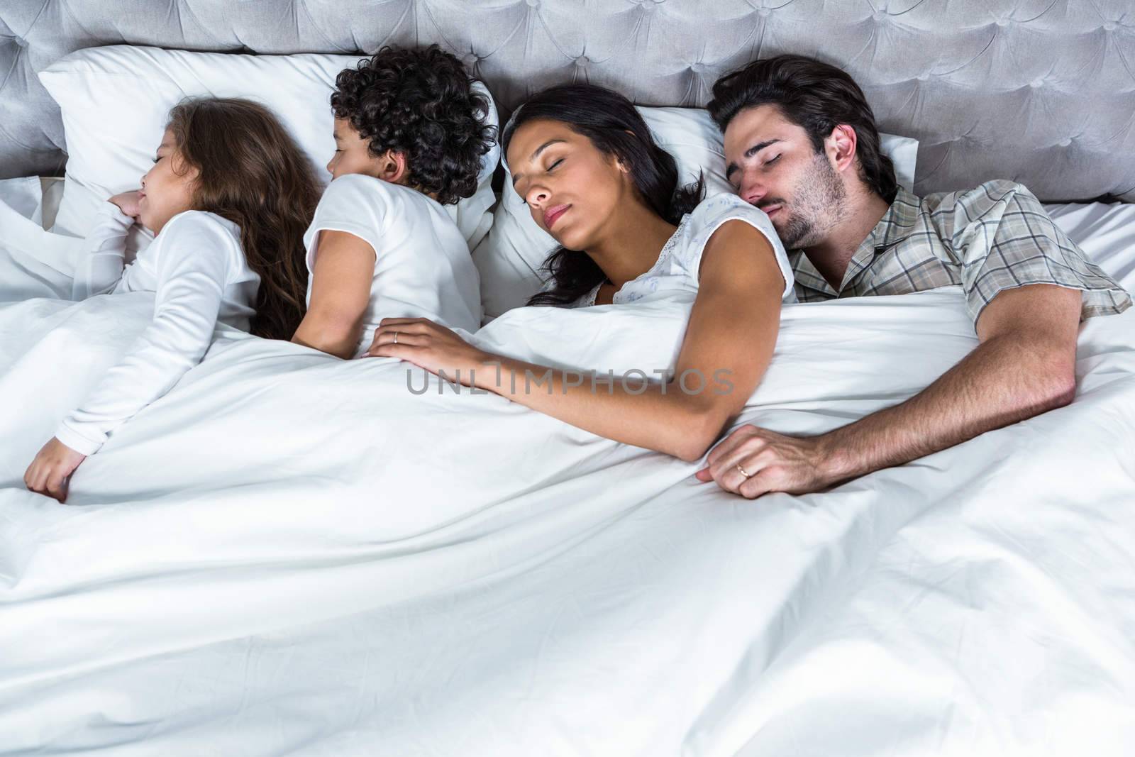 Family sleeping together in bed 