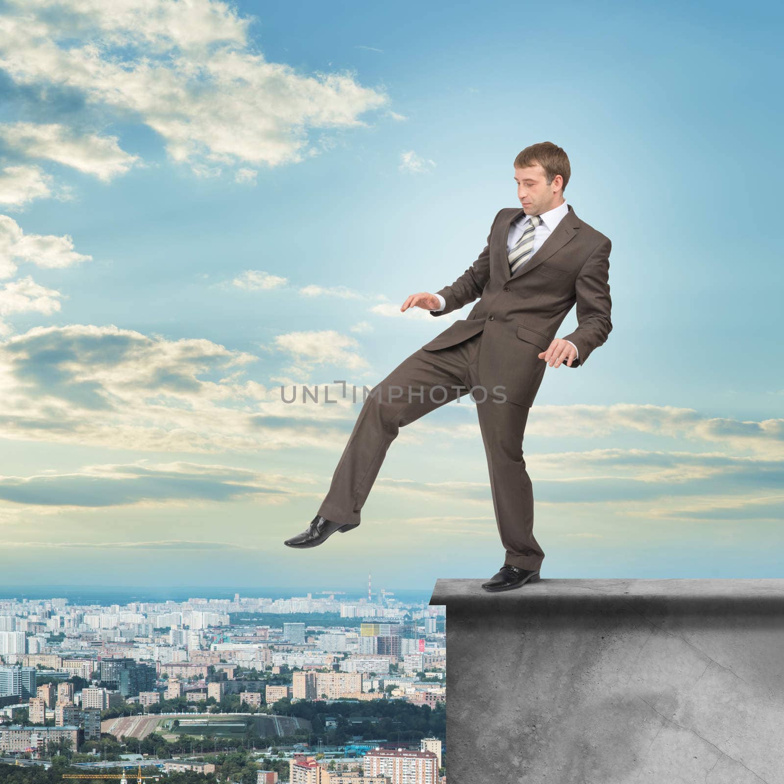 Man stepping from edge of building roof with band on his eyes