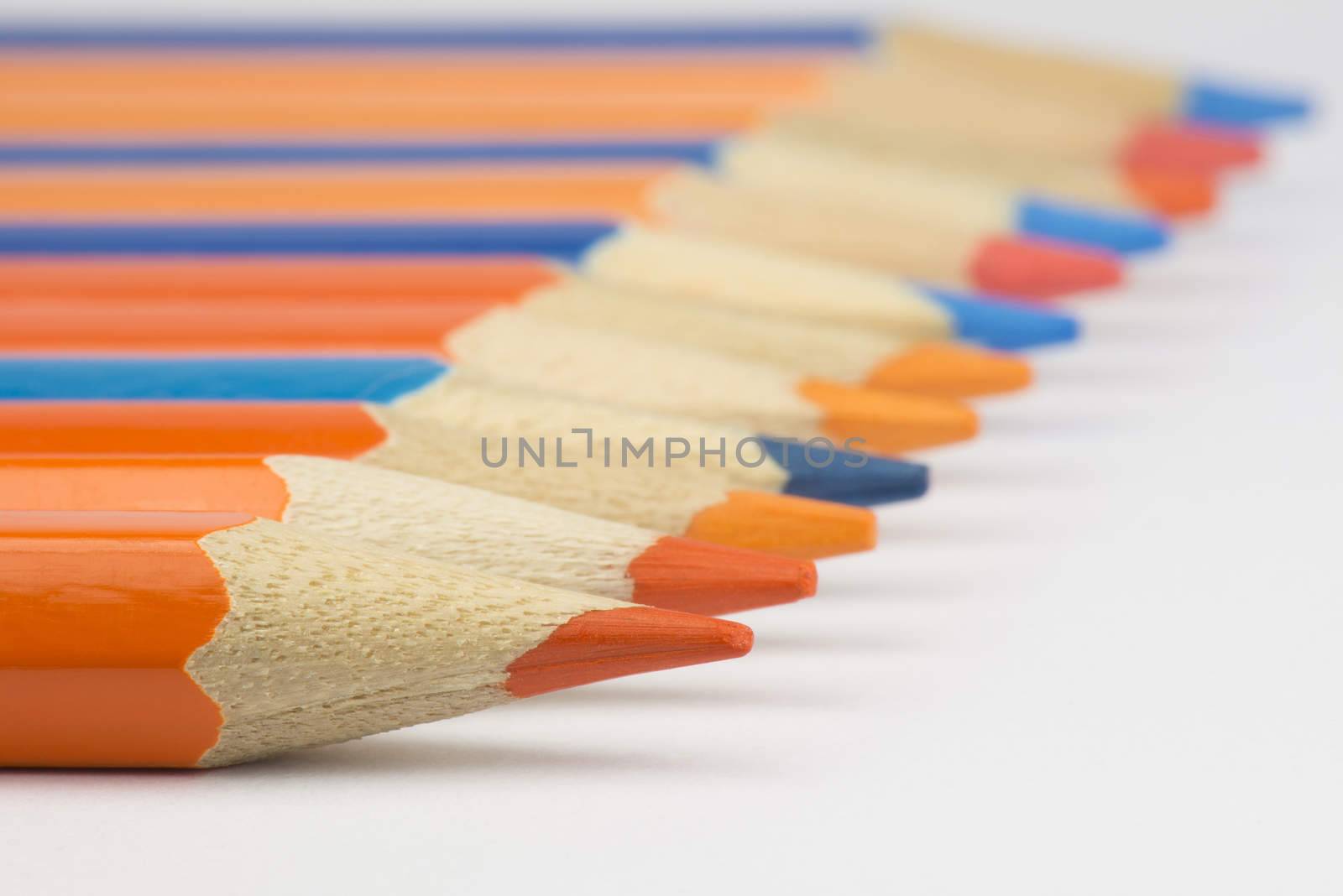 Abstract composition of a set wooden colour pencils against a white background
