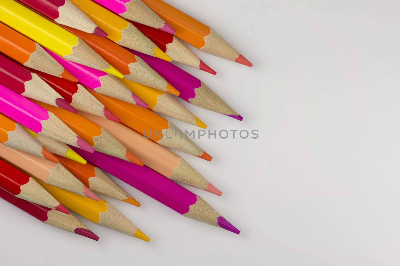 Abstract composition of a set wooden colour pencils against a white background
