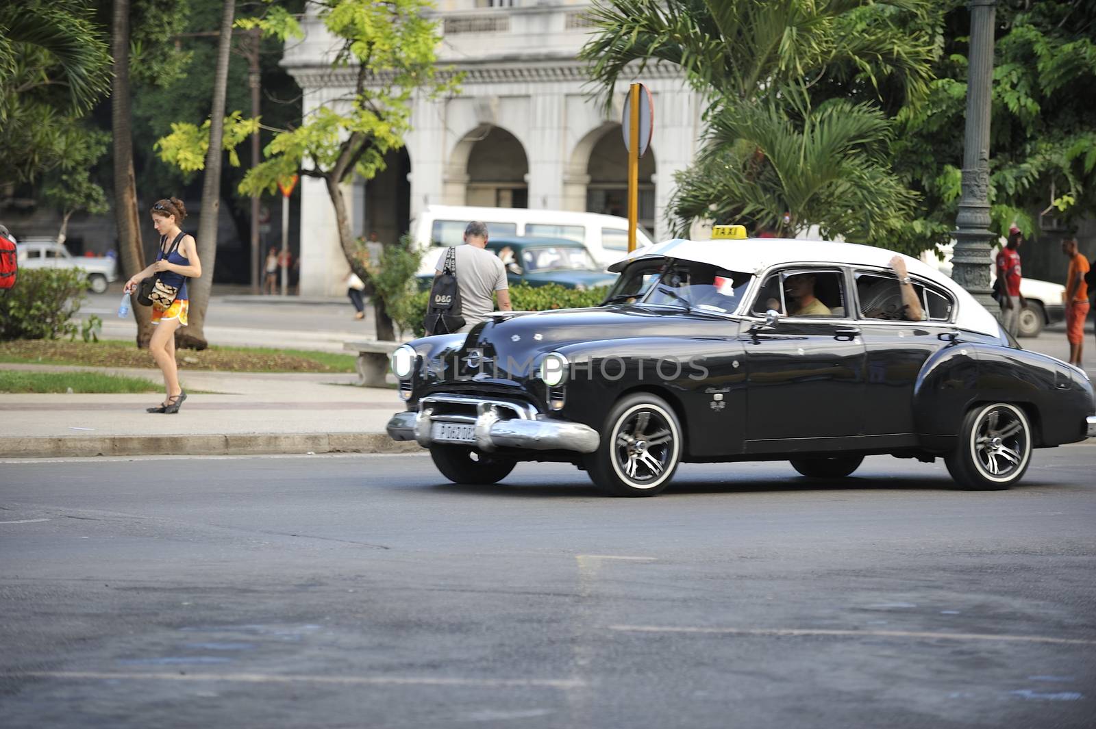 Old Havana, Cuba, -  August  2013. The old vintage-styled car in the historical center of Havana is waiting for the tourists to board. Riding an auto of the 20's - 50's is one of the attractions for the tourists in Cuba. Such cars are used for any goal, not only tourism, but taxis and personal needs.