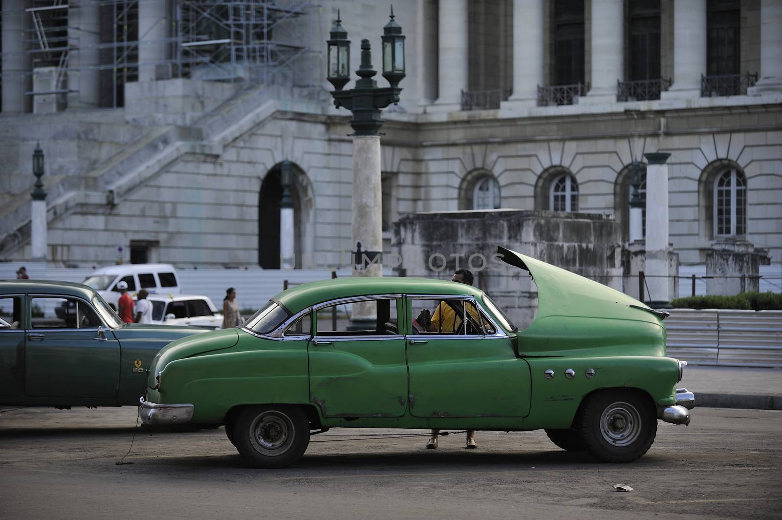 Old Havana, Cuba, -  August  2013. The old vintage-styled car in the historical center of Havana is waiting for the tourists to board. Riding an auto of the 20's - 50's is one of the attractions for the tourists in Cuba. Such cars are used for any goal, not only tourism, but taxis and personal needs.