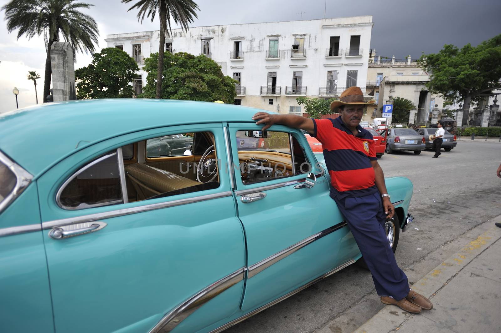 Old Havana, Cuba, -  August  2013. The old vintage-styled car in the historical center of Havana is waiting for the tourists to board. Riding an auto of the 20's - 50's is one of the attractions for the tourists in Cuba. Such cars are used for any goal, not only tourism, but taxis and personal needs.