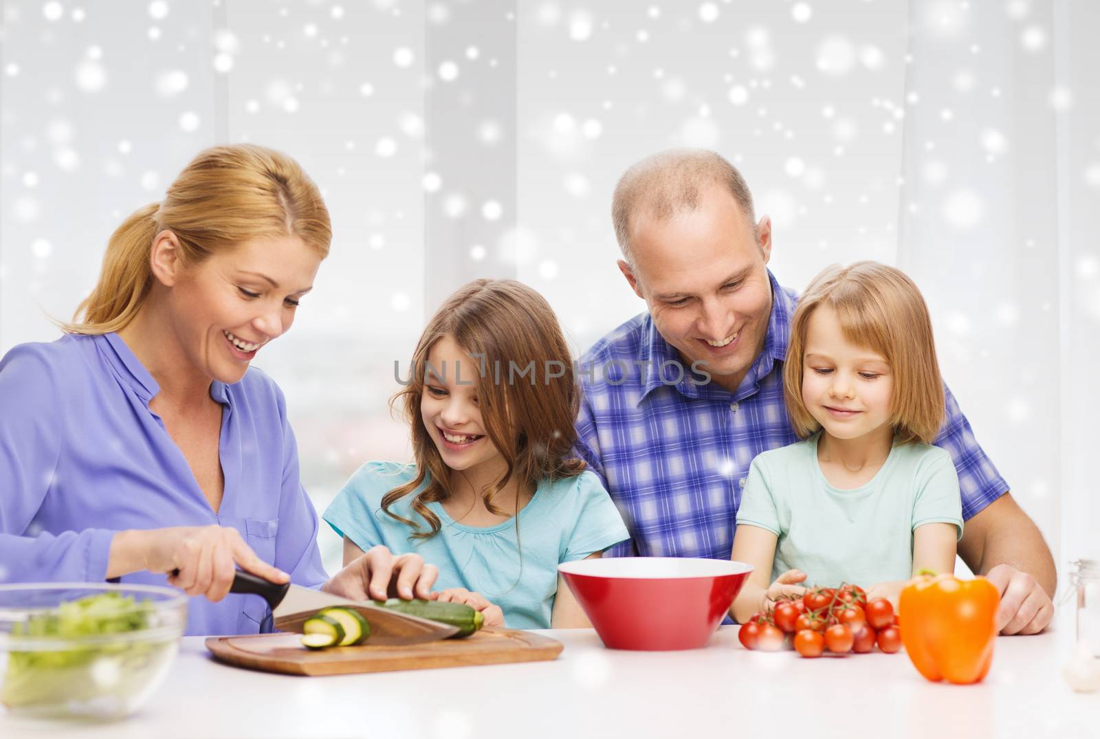 happy family with two kids making dinner at home by dolgachov