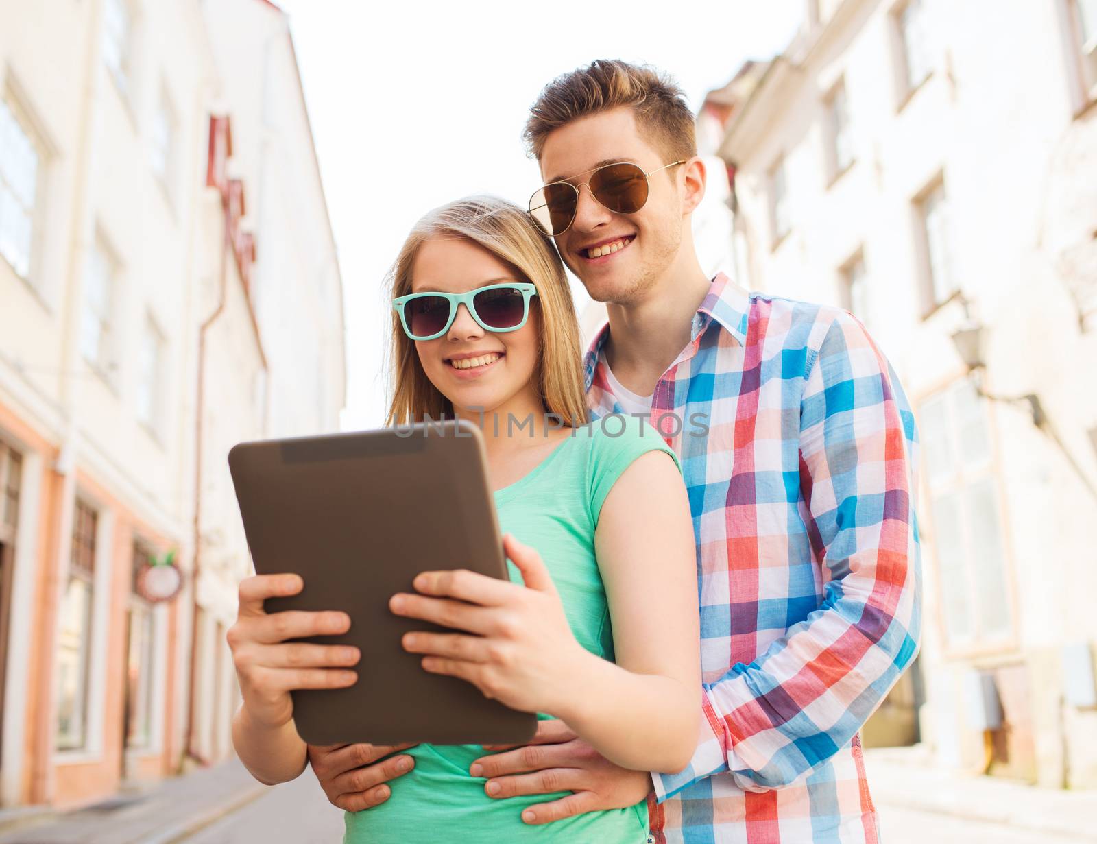 smiling couple with tablet pc in city by dolgachov