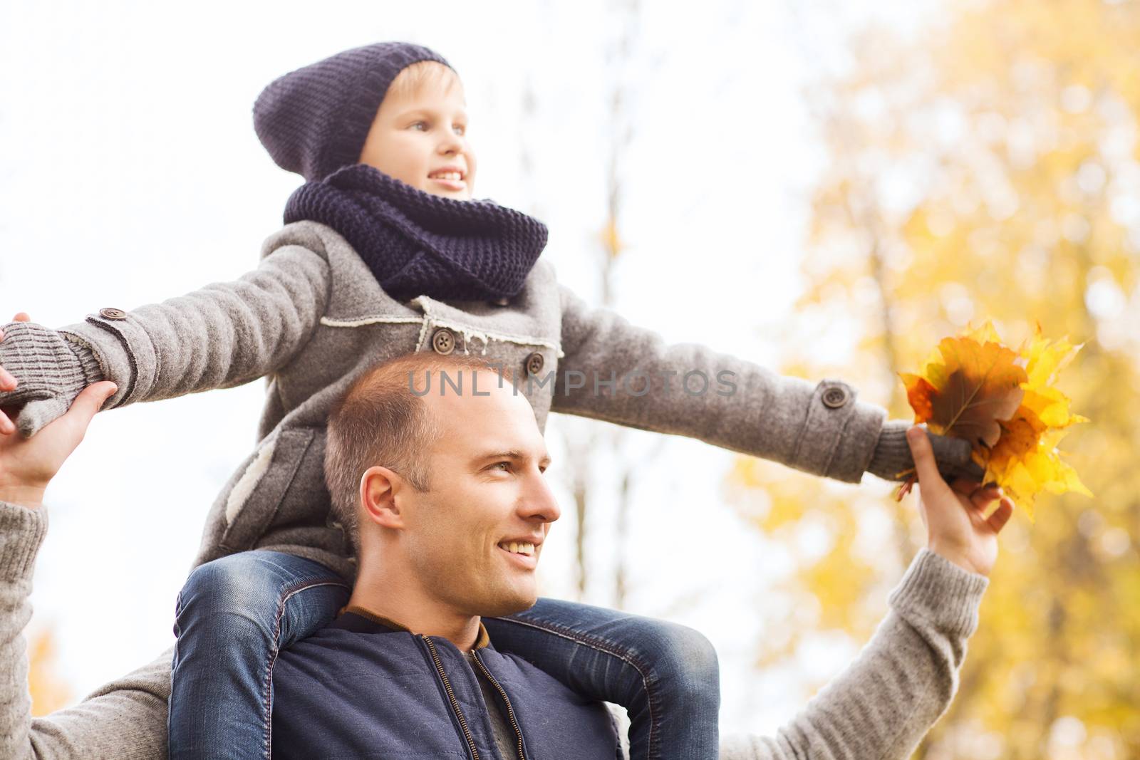 family, childhood, season and people concept - happy father and son having fun in autumn park