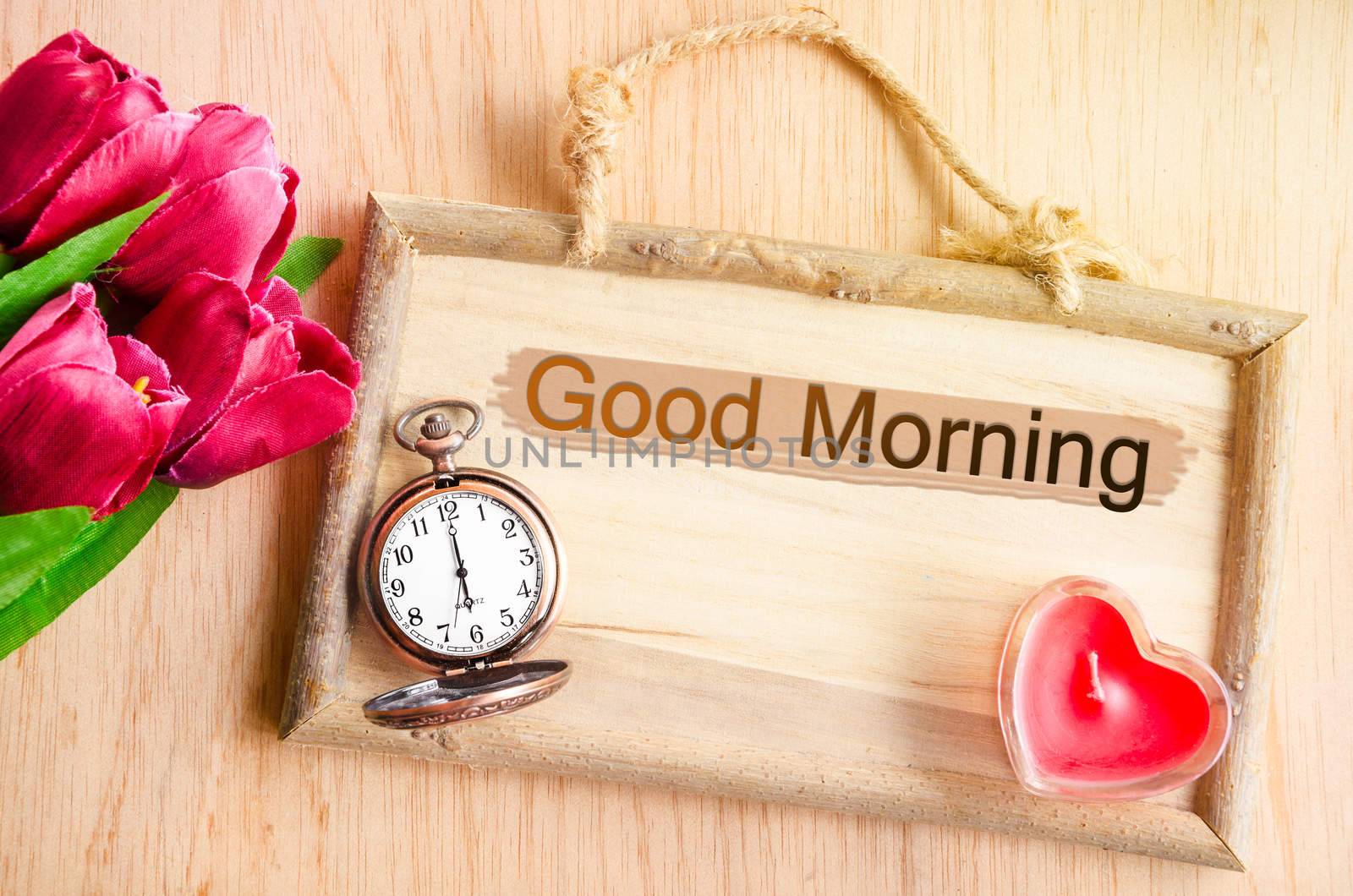 Good morning. Clock and red tulip with red candle heart shape on wooden background.