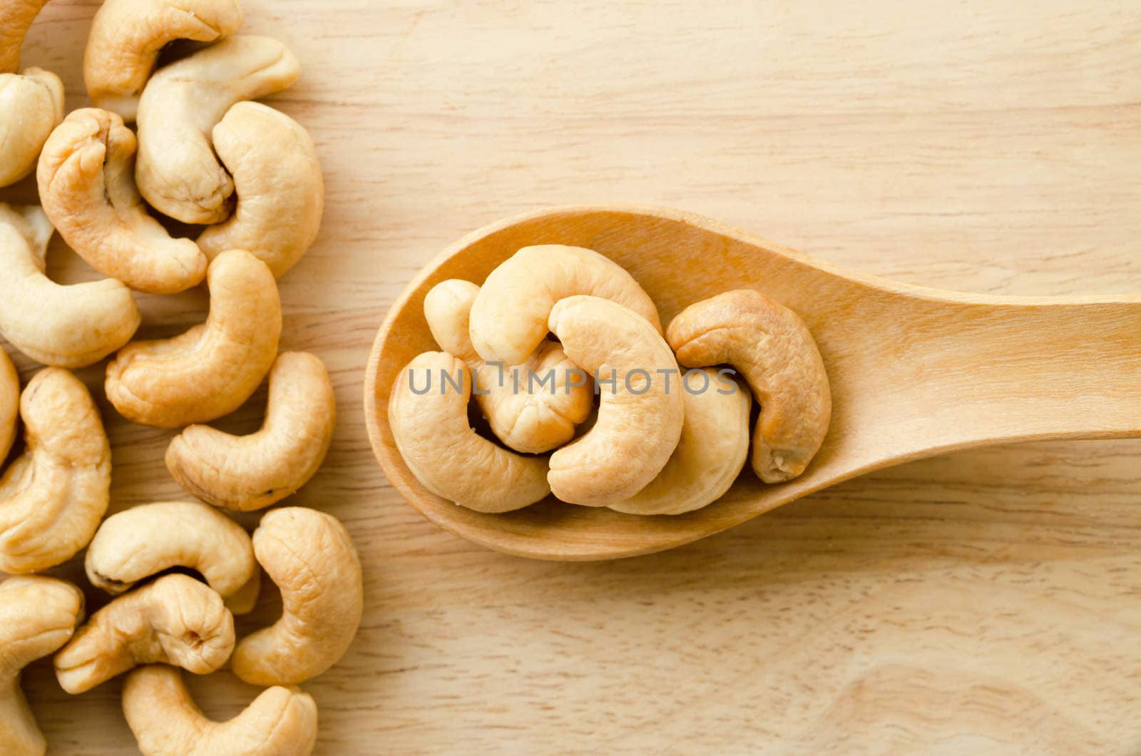 cashew nuts with salt on wooden background.
