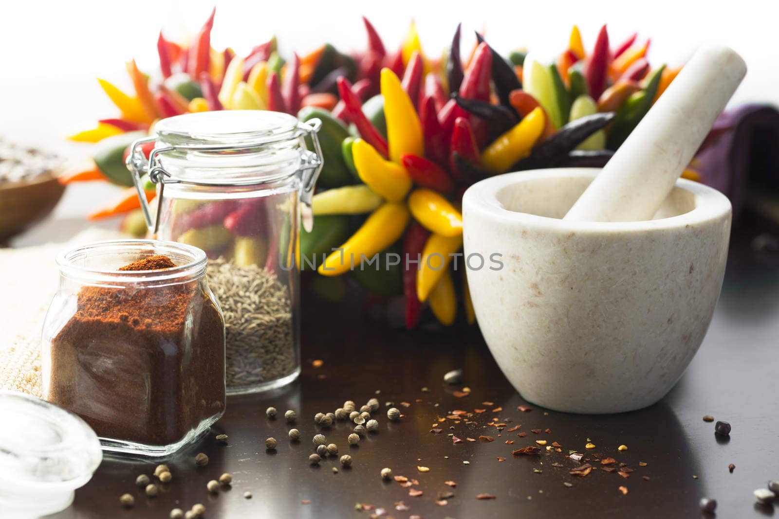 Fresh colorful chili peppers and ground chili pepper with mortar and pestle.