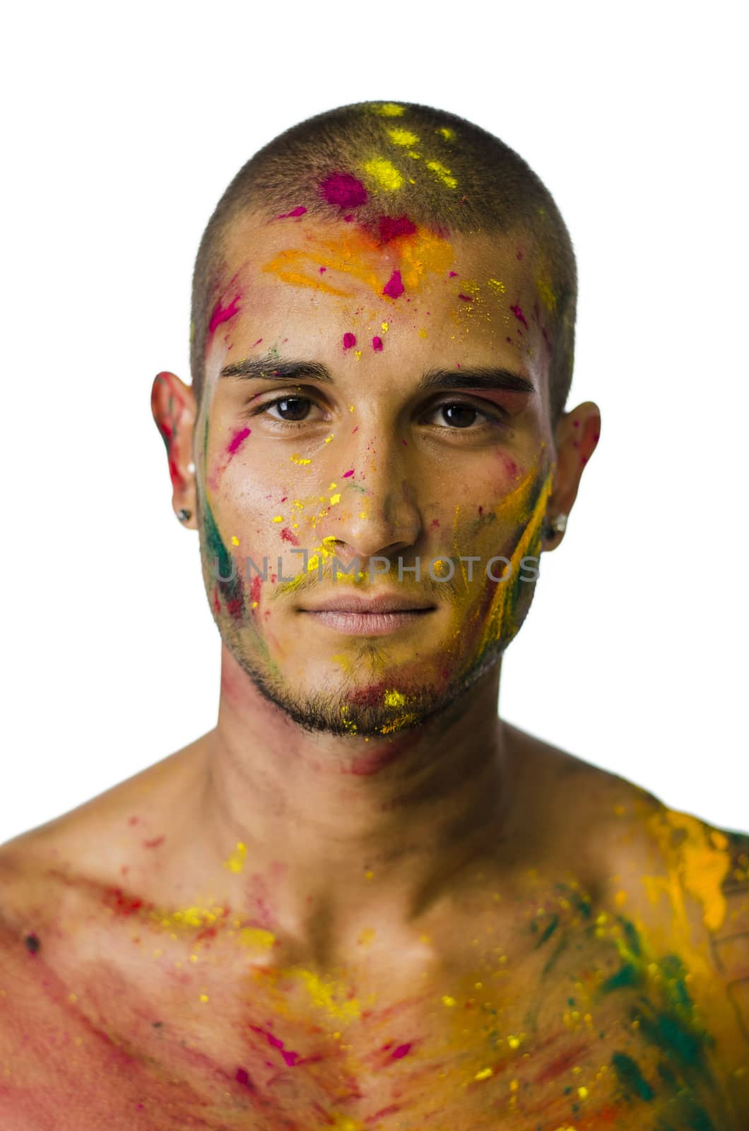 Head and shoulders shot of attractive young man shirtless, skin painted all over with bright Holi colors, looking at camera, isolated on white background