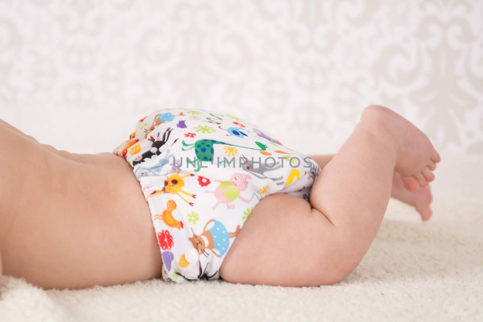 Close-up on a reusable white nappy with colorful animals pattern