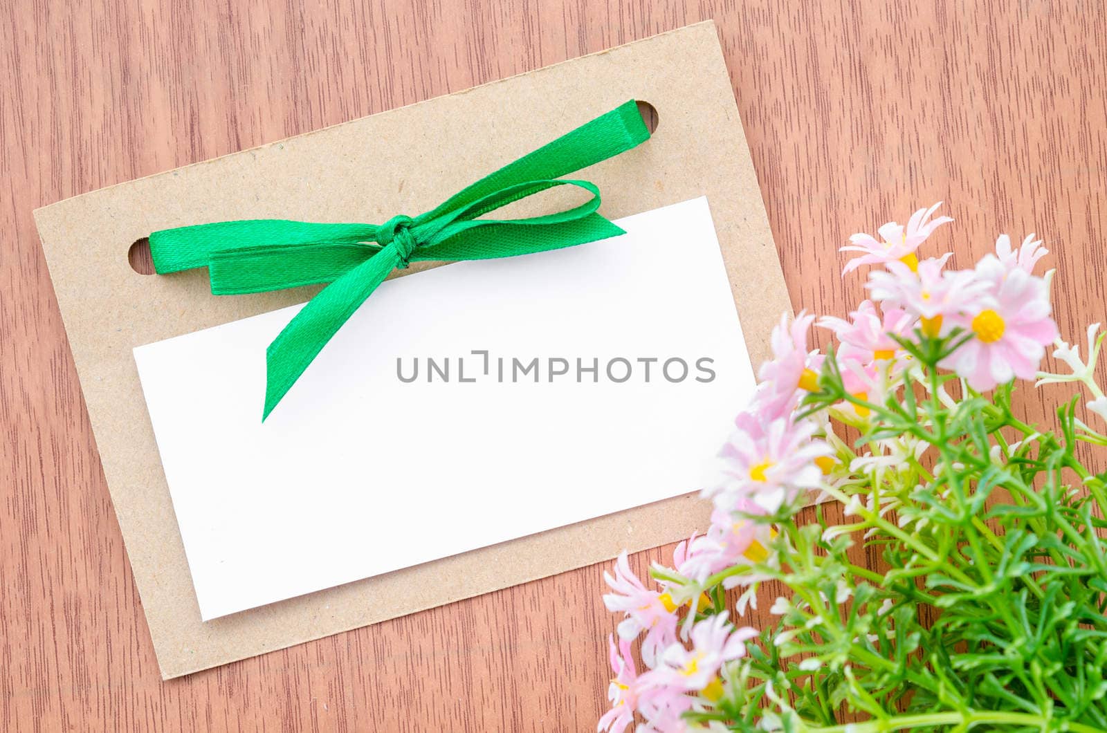 flowers and empty tag for your text on turquoise painted wooden background. Selective focus in on tag. Square image.