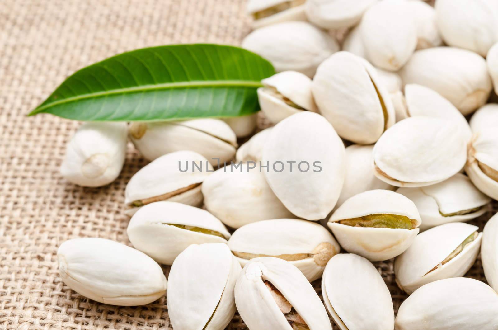 Roasted pistachios on natural sack background.