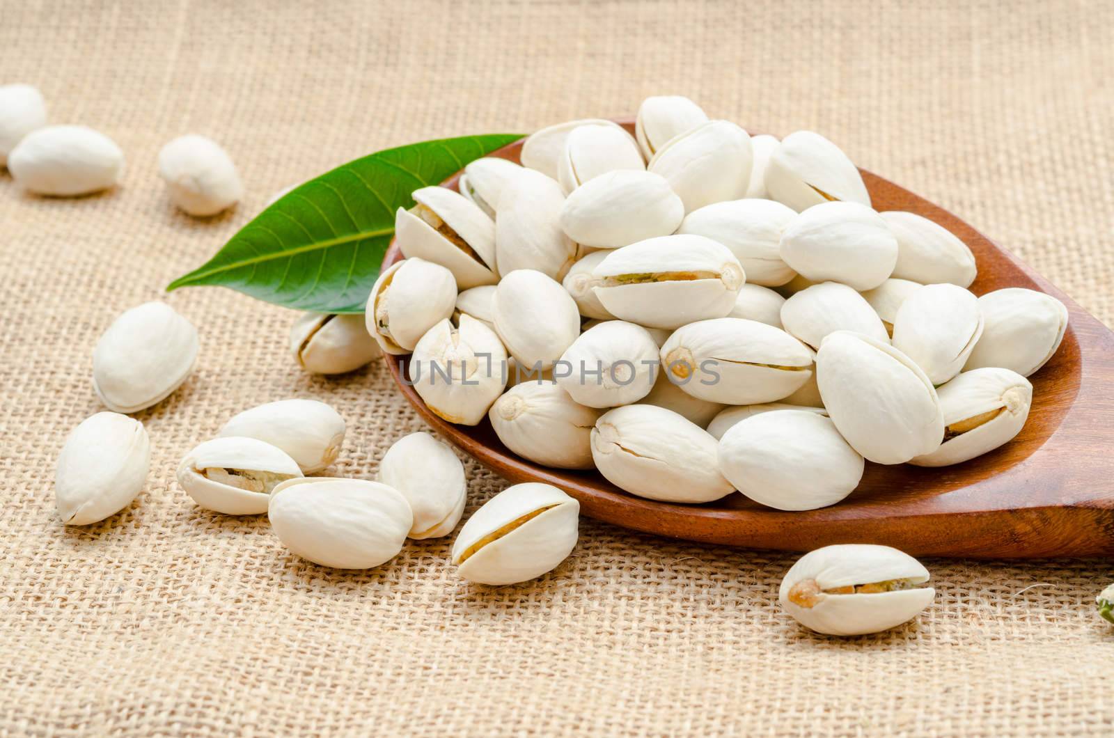 Roasted pistachios on natural sack background.