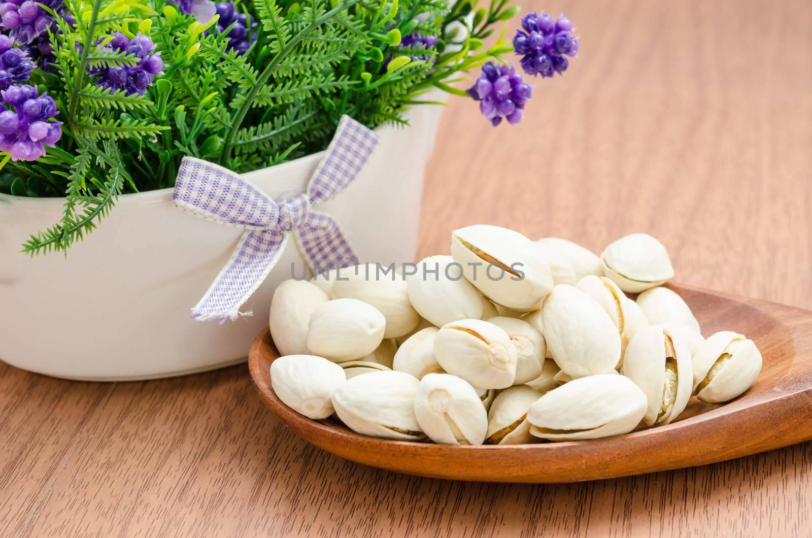 Pistachios. Selective focus and flower on wooden background.