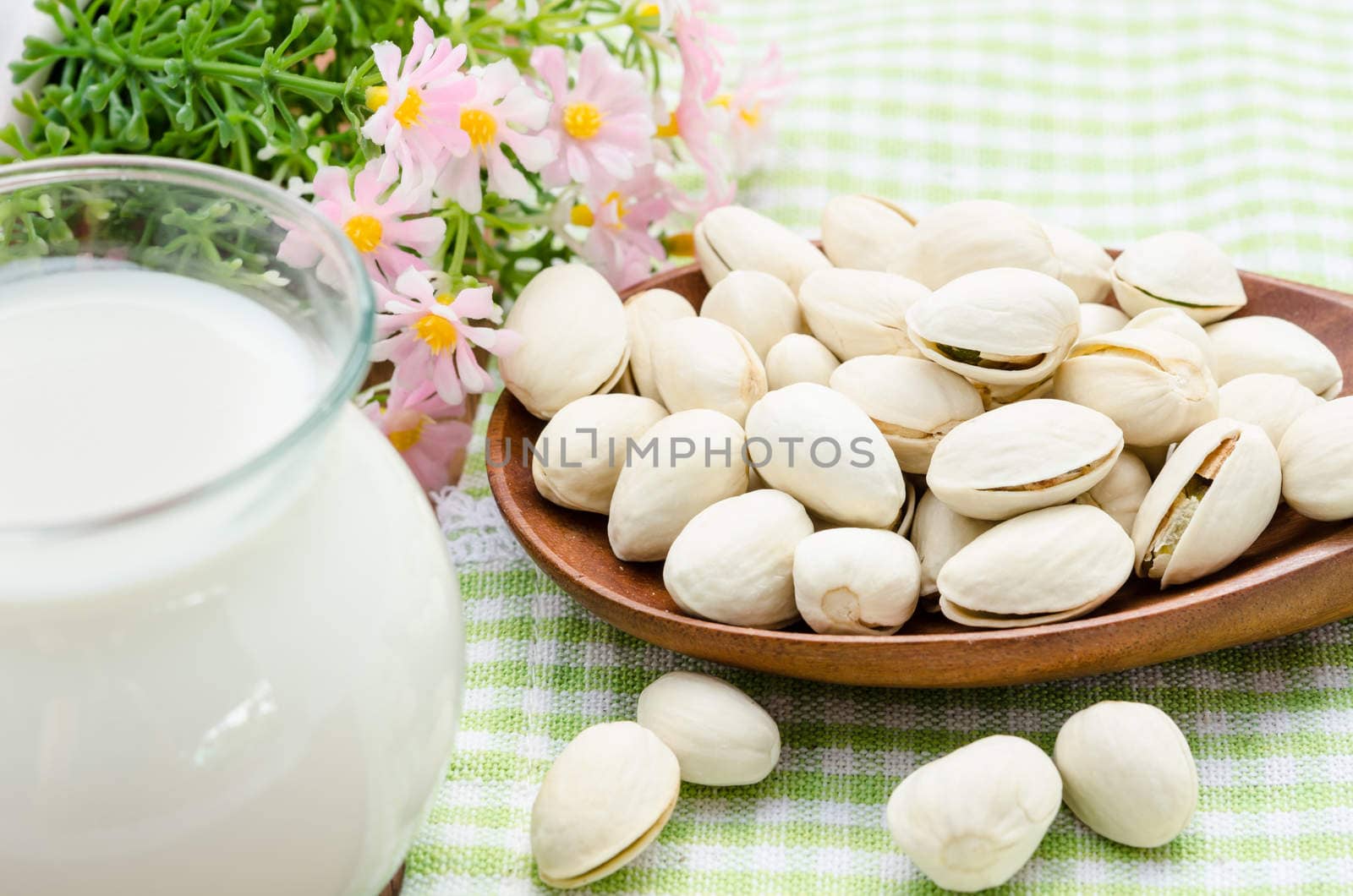 Raw Organic Pistachio Nuts in a Bowl and milk in glass.