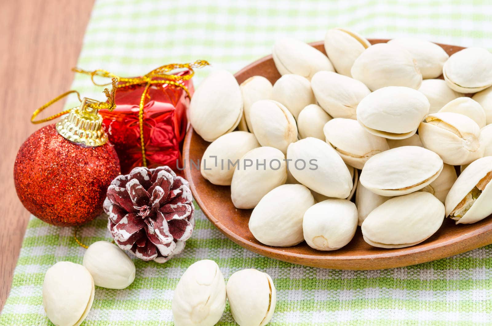 Pistachios. Selective focus in wooden spoon and decoration christmas on table.