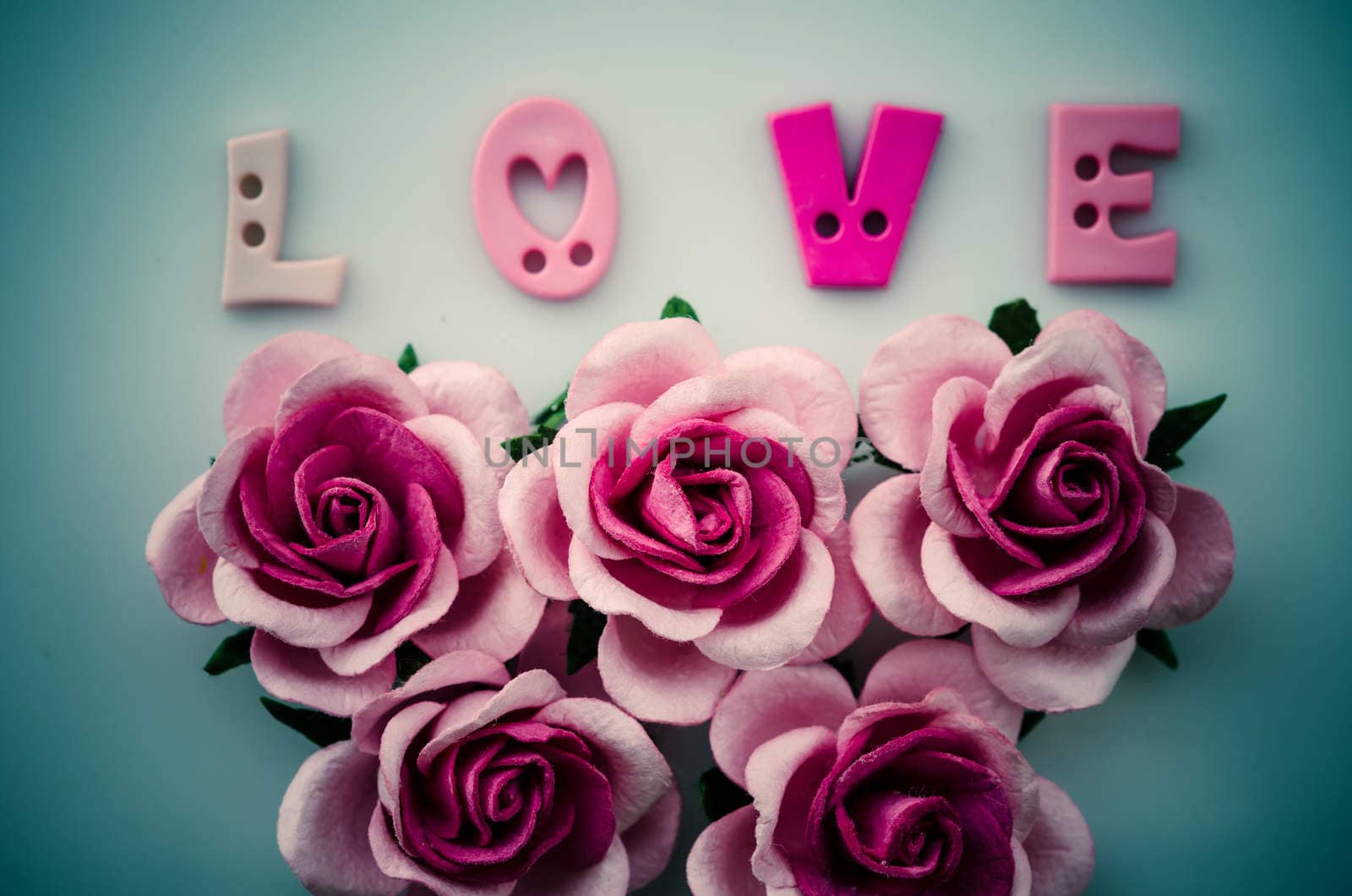 Vintage pink roses flower and love text on blue background.