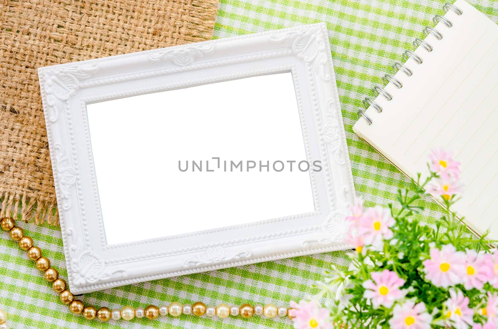 Blank vintage white photo frame and open diary with pink flower on fabric background. Save clipping path.