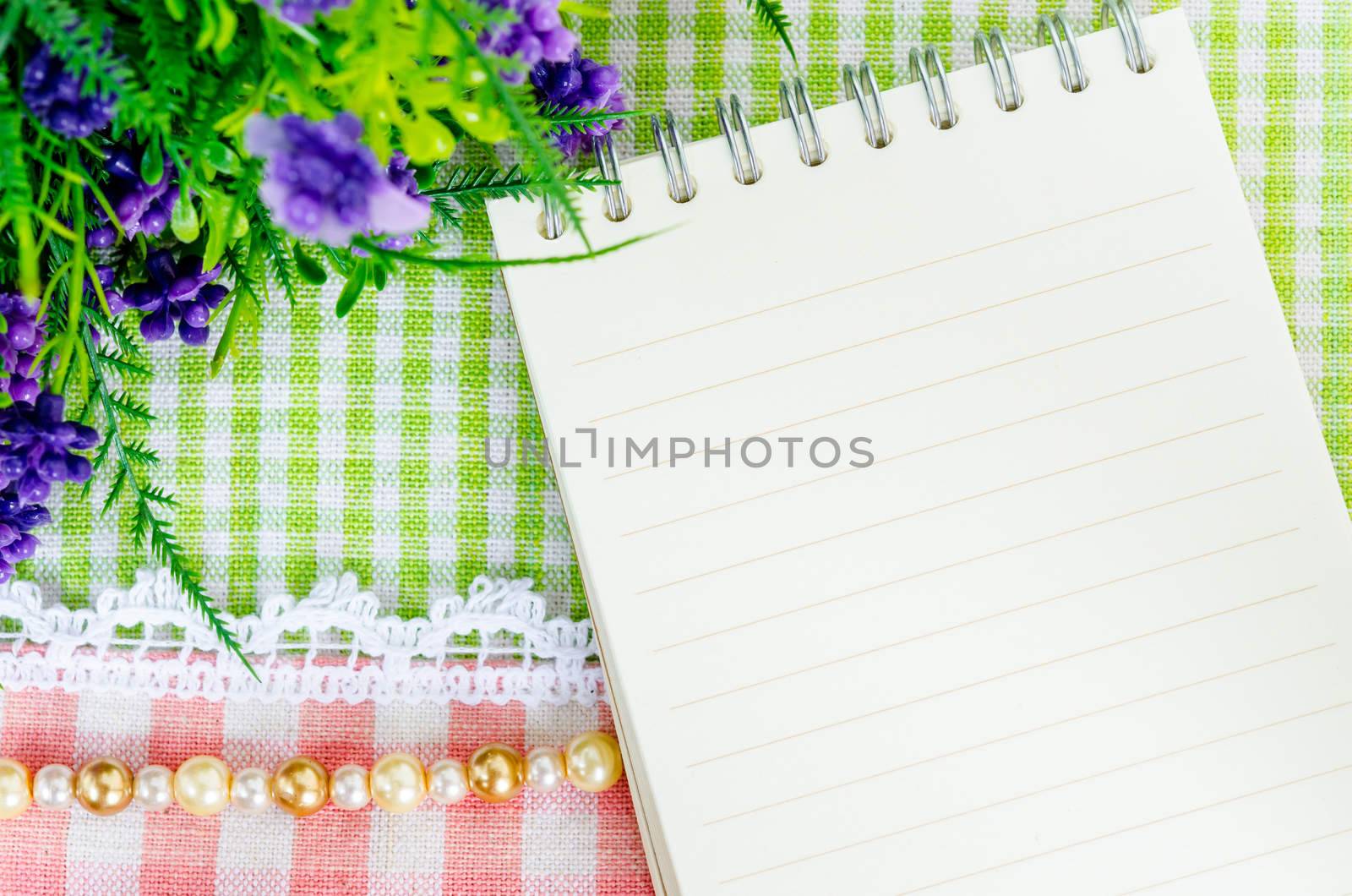Open diary and violet flower on beautiful background from tob view. Fre space for your text.