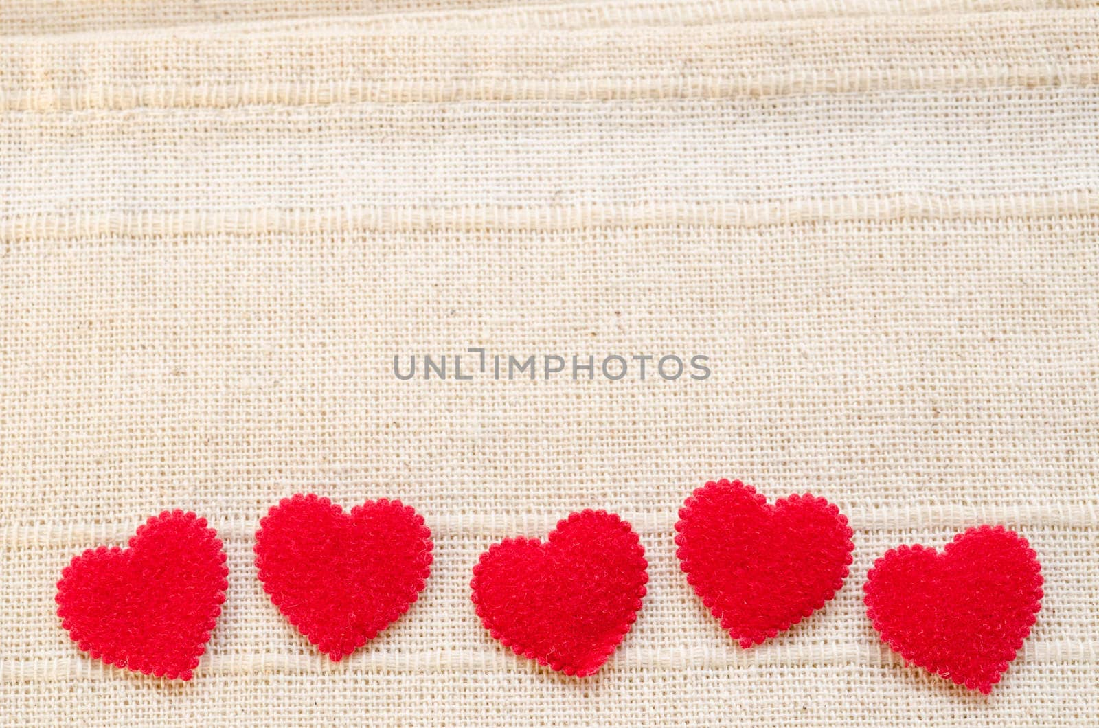 Red heart fabric on vintage fabric background with empty space. Love concept background.