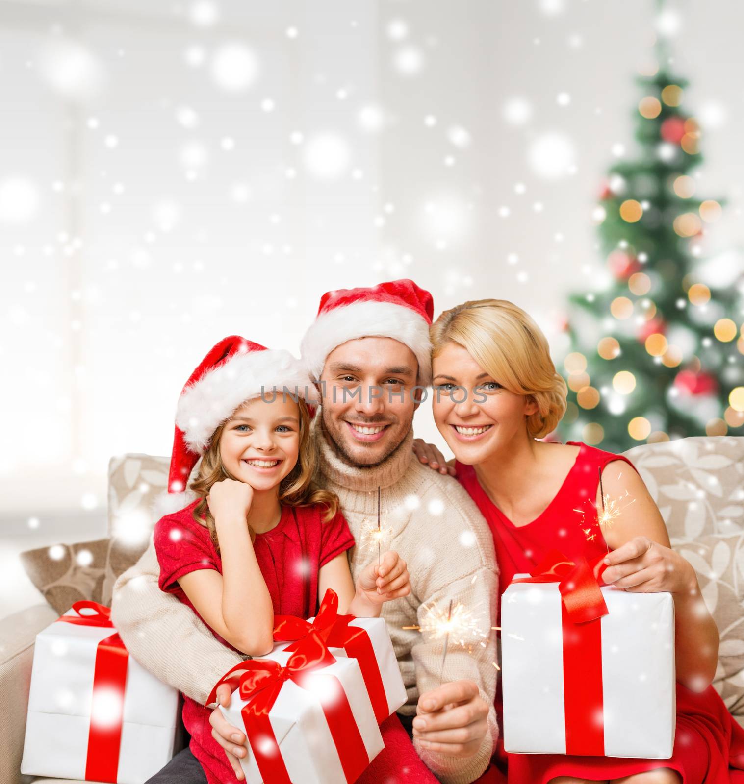 christmas, holidays, happiness and people concept - smiling family in santa helper hats with many gift boxes and sparklers at home
