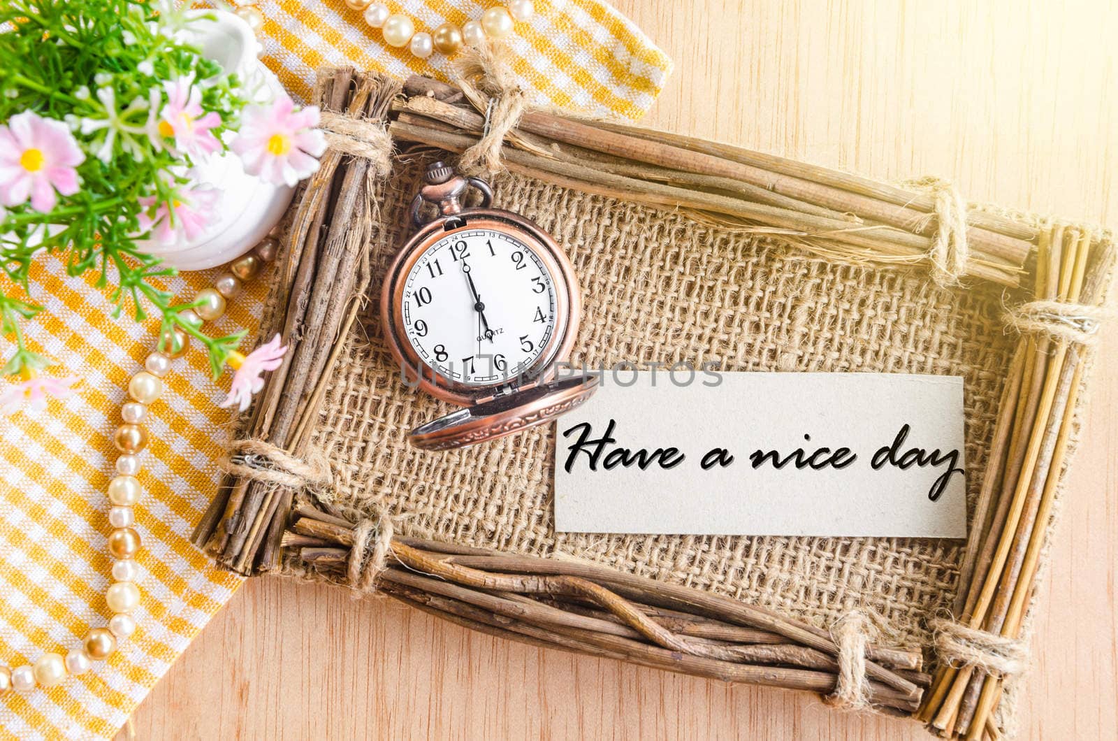 Have a nice day text in sack photo frame with flower on wooden background.