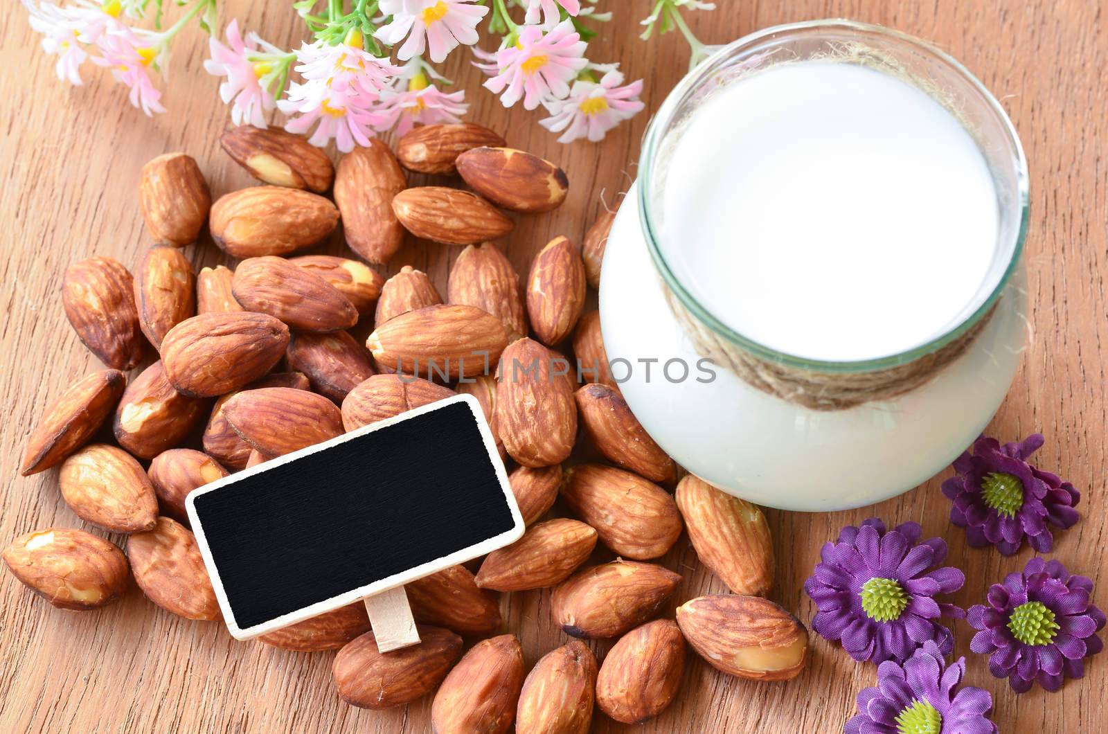 Almond and almond milk with blank black wooden tag for your text by Gamjai