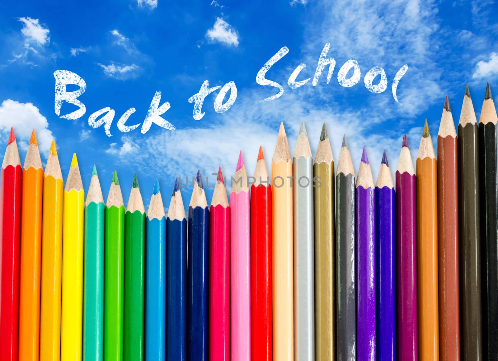 A pencil crayon border on blue sky background with words back to school. save clipping path